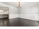 Formal dining room with wainscoting, dark hardwood floors, and elegant chandelier at 3415 Kenyon Creek Nw Dr, Kennesaw, GA 30152