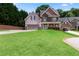 Inviting two-story home with a stone and siding exterior, lush front lawn, and an attached two-car garage, exuding charm at 3415 Kenyon Creek Nw Dr, Kennesaw, GA 30152