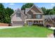 Charming two-story home with a stone and siding exterior and well-manicured lawn at 3415 Kenyon Creek Nw Dr, Kennesaw, GA 30152