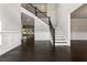 Open foyer with dark wood floors, a staircase with black railings, and paneled walls at 3415 Kenyon Creek Nw Dr, Kennesaw, GA 30152