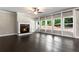 Cozy living room with fireplace, ceiling fan, and large windows offering natural light at 3415 Kenyon Creek Nw Dr, Kennesaw, GA 30152