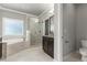 Stunning main bathroom features a marble shower, tile flooring, garden tub, and dark cabinetry at 3415 Kenyon Creek Nw Dr, Kennesaw, GA 30152