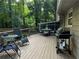Spacious wooden deck with outdoor seating, a grill, and tranquil views of the lush, green backyard at 3474 Leaf Land Ct, Duluth, GA 30097