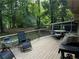 Spacious wooden deck with outdoor seating, a grill, and tranquil views of the lush, green backyard at 3474 Leaf Land Ct, Duluth, GA 30097