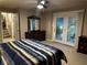 Spacious main bedroom with french doors to an outdoor patio and a dark wood dresser at 3474 Leaf Land Ct, Duluth, GA 30097