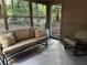 Inviting screened-in porch with a cozy couch and chair, and views of the serene, wooded backyard at 3474 Leaf Land Ct, Duluth, GA 30097