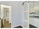 Hallway with a sliding barn door provides a peek into the modern kitchen, and the bathroom is nearby at 3820 Roswell Ne Rd # 510, Atlanta, GA 30342