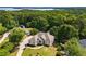Aerial shot of the home with mature trees and a view of the water in the distance at 7025 Bavarian Wood Pl, Buford, GA 30518