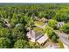 An aerial view of a beautiful suburban home surrounded by mature trees in a quiet neighborhood at 7025 Bavarian Wood Pl, Buford, GA 30518