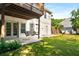 A view of the exterior with a wooden swing set and a grassy backyard at 7025 Bavarian Wood Pl, Buford, GA 30518