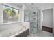 Bright bathroom with a soaking tub, glass-enclosed shower, and modern fixtures at 7025 Bavarian Wood Pl, Buford, GA 30518