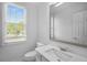Bright bathroom featuring white fixtures and natural light from a large window at 7025 Bavarian Wood Pl, Buford, GA 30518