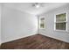Bedroom featuring hardwood floors, natural light from two windows, and ceiling fan at 7025 Bavarian Wood Pl, Buford, GA 30518