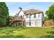 Beautiful backyard featuring a large lawn, trees, a patio, and wooden deck at 7025 Bavarian Wood Pl, Buford, GA 30518