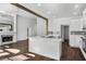 Modern kitchen with white cabinets, island, and open layout to the living room area at 7025 Bavarian Wood Pl, Buford, GA 30518