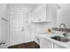 Bright laundry room with white cabinets, quartz countertops, and modern sink fixtures at 7025 Bavarian Wood Pl, Buford, GA 30518