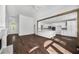 Open living room with hardwood floors flowing into the kitchen featuring white cabinetry at 7025 Bavarian Wood Pl, Buford, GA 30518