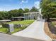 Modern home featuring a long driveway, lush landscaping, and stylish exterior finishes under a blue sky at 1603 Ezra Church Nw Dr, Atlanta, GA 30314