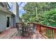 View of outdoor deck with weathered wood, dark metal patio set, and a light blue colored home exterior at 1882 Flowering Dr, Grayson, GA 30017