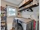 Functional laundry room with modern washer and dryer, storage shelves, and natural light at 1882 Flowering Dr, Grayson, GA 30017