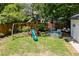 Well-manicured backyard featuring a playset, stock tank pool, and lush green lawn at 1256 Euclid Ne Ave, Atlanta, GA 30307