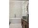 Stylish bathroom featuring modern tub, marble floors, and elegant floral wallpaper at 1256 Euclid Ne Ave, Atlanta, GA 30307