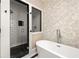 Elegant bathroom featuring a modern shower and a luxurious soaking tub with floral wallpaper at 1256 Euclid Ne Ave, Atlanta, GA 30307