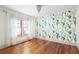 Bright bedroom with hardwood floors, ample natural light, and a unique cactus-themed wallpaper at 1256 Euclid Ne Ave, Atlanta, GA 30307