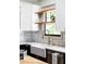 Bright kitchen boasts white countertops, farmhouse sink with gold faucet, and floating shelves at 1256 Euclid Ne Ave, Atlanta, GA 30307