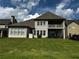 Spacious backyard with manicured lawn and a two-story house featuring a covered back patio at 2657 Gray Mill Way, Loganville, GA 30052