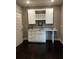 A stylish bar features granite countertops, wooden cabinets, and dark hardwood floors at 2657 Gray Mill Way, Loganville, GA 30052