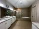 Bathroom with double sinks, granite countertops, a glass shower, and a soaking tub at 2657 Gray Mill Way, Loganville, GA 30052
