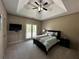 Bedroom featuring tray ceiling, ceiling fan, and sliding door access to a balcony at 2657 Gray Mill Way, Loganville, GA 30052