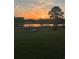 Picturesque lake view at sunset with the sun reflecting on the water and trees silhouetted in the distance at 2657 Gray Mill Way, Loganville, GA 30052