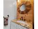 Stylish powder room features a wood accent wall and a custom round mirror above the granite countertop at 5440 Old Haven Ct, Cumming, GA 30041