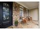 Cozy front porch featuring stone accents, decorative chairs, and an elegant front door at 5440 Old Haven Ct, Cumming, GA 30041