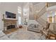 Bright living room with a stone fireplace, hardwood floors, and staircase access at 5440 Old Haven Ct, Cumming, GA 30041