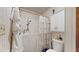 This bathroom features a walk-in shower, white cabinets, and neutral wallpaper at 6 Fairfield Dr, Ellenwood, GA 30294