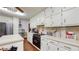 Well-lit kitchen featuring white cabinets, countertops, and dark wood flooring at 6 Fairfield Dr, Ellenwood, GA 30294