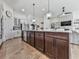 Open-concept kitchen showcasing a large island with dark wood cabinets and stunning lighting fixtures above at 603 Canyon Overlook, Canton, GA 30114