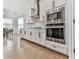 Chef's kitchen boasts stainless steel appliances, white cabinetry, and a stylish tile backsplash at 603 Canyon Overlook, Canton, GA 30114