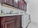This laundry room boasts ample cabinet space above a sink, with a modern, front-loading washer and dryer set at 603 Canyon Overlook, Canton, GA 30114