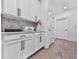 Bright mud room with white cabinets, brick backsplash, and durable wood-look flooring. Fresh and inviting at 603 Canyon Overlook, Canton, GA 30114