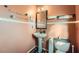 Small, colorful bathroom with a pedestal sink, a toilet, and unique wall decorations at 2331 Flowerdale Ct, Douglasville, GA 30135