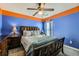 This bedroom has bright blue walls, orange trim, and a beautiful ceiling fan and window light at 2331 Flowerdale Ct, Douglasville, GA 30135
