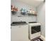 Clean laundry room with washer, dryer, shelving and grey paint at 2331 Flowerdale Ct, Douglasville, GA 30135