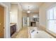 Well-lit bathroom featuring a garden tub, separate vanities, and travertine tile at 2604 Heltonwood Ct, Buford, GA 30519