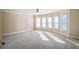Spacious bedroom featuring plush carpet, a ceiling fan, and multiple windows providing ample natural light at 2604 Heltonwood Ct, Buford, GA 30519
