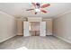 Open view of a bedroom with a ceiling fan and doors opening to the hallway with wooden banisters at 2604 Heltonwood Ct, Buford, GA 30519
