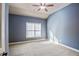 Cozy bedroom with blue walls, plush carpet, a ceiling fan, and natural light from a window at 2604 Heltonwood Ct, Buford, GA 30519
